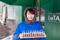 Happy Japanese woman standing in front of chocolate shop in Otaru, Japan with tray of chocolate samples