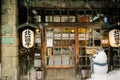 Front of vintage and ancient Japanese restaurant with snowman doll in snowing winter.