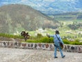 OTAVALO, ECUADOR - Feb 16, 2008: Hispanic Man Walks While Catching a Flying Falcon Against Andes Mountains Background