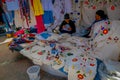 OTAVALO, ECUADOR, NOVEMBER 06, 2018: Unidentified women eating the lunch and selling the typical andean fabrics sold on