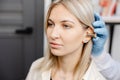 Otolaryngologist doctor checking young woman\'s ear using otoscope or auriscope at ENT clinic, close up. Hearing exam Royalty Free Stock Photo