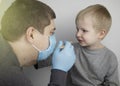 An otolaryngologist examines a child`s throat with a wooden spatula. A possible diagnosis is inflammation of the pharynx, tonsils Royalty Free Stock Photo