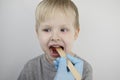An otolaryngologist examines a child`s throat with a wooden spatula. A possible diagnosis is inflammation of the pharynx, tonsils Royalty Free Stock Photo