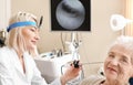 Otolaryngologist examining senior woman's ear with ENT telescope in hospital Royalty Free Stock Photo