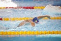 Details with a professional female athlete swimming in an olympic swimming pool