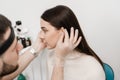 Otoplasty ear surgery. Surgeon doctor examines girl ears before otoplasty cosmetic surgery. Otoplasty surgical reshaping