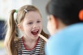 Otorhinolaryngologist doctor examining sore throat little girl in clinic