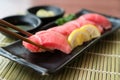 Otoro tuna sushi on black plate along with Japanese sauce and gr Royalty Free Stock Photo