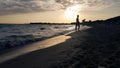 People relaxing at the sea with turquoise water and golden beach at sunset in Alimini, Salento,Puglia, Italy