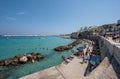 Otranto, Puglia, Italy. August 2021. Amazing view of the promenade, people enjoy the crystal clear sea while swimming. Beautiful