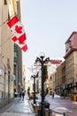 Sparks street with canadian flags on building and people walking in downtown district of Ottawa in Canada