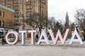 Ottawa sign in downtown at the Byward Market with Canadian Parliament in background. Royalty Free Stock Photo