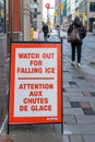 Street sign on the sidewalk warning people of the danger of ice and snow falling from the building Royalty Free Stock Photo