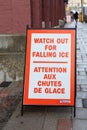 Street sign on the sidewalk warning of the danger of ice and snow falling from the building Royalty Free Stock Photo