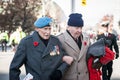 Two Canadian Army war veteran, senior men, with their medals and remembrance poppy, paying respects to dead soldiers