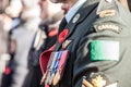 Details of the uniform of Canadian Army ground forces with the Remembrance poppy and medals, seen from behind
