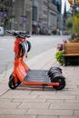Electric scooter for rent on the street. Orange E-scooter on the sidewalk in downtown Ottawa, Canada