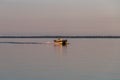 People on a pontoon boat on Otter Tail Lake at sunset in rural Minnesota.