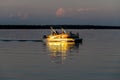 People on a pontoon boat on Otter Tail Lake at sunset in rural Minnesota.