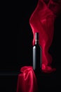 Ãâottle of red wine with flutters red cloth Royalty Free Stock Photo