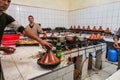 Ouarzazate, Morocco - Oct 21, 2019: Young moroccan man cooking tajine with vegetables and showing it to the tourist