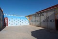 Ouarzazate, Morocco - October 10, 2023: Rainbow painted wall and an English telephone booth and many old telephones