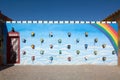 Ouarzazate, Morocco - October 10, 2023: Rainbow painted wall and an English telephone booth and many old telephones Royalty Free Stock Photo