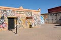 Ouarzazate, Morocco - October 10, 2023: Wall painted with the faces of artists and different graffiti and a young boy