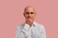 Ouch. I really said it. Close up portrait of bald man with bristle in white shirt cover open mouth by hand palm, look at