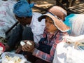 Woman peeling palmyra palm fruit pods at a street market in Oudong