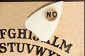 Ouija board with the planchette pointing to NO