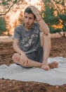 Young Arab model sitting on a white picnic blanket outdoors