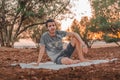 Young Arab model sitting on a white picnic blanket outdoors