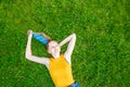 Oung blonde girl lies on green grass. Relaxation and meditation concept. Relaxation and meditation concept. Y