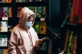 Oung girl in face mask in book shop