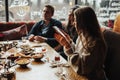 Oung girl is taking pictures of food. A young company of people is smoking a hookah and communicating in an oriental restaurant. L Royalty Free Stock Photo