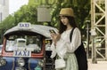 Asian Young lady tourist using a smart phone in the road looking some application map Royalty Free Stock Photo