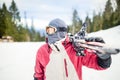 Oung man holding ski.Skier holding skis looking at the mountains.Side view of handsome skier man with mask and holding ski equipme Royalty Free Stock Photo