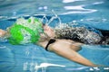 Oung man swimmer with green cap swims front crawl or forward crawl stroke in a swimming pool for competition or race Royalty Free Stock Photo