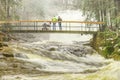 oung parents with baby in pram on bridge over flood river