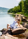 Oung, girl in a dress on the river bank, rocks