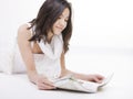 Oung teen girl in white dress reading on floor Royalty Free Stock Photo