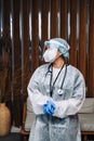 Oung woman nurse worker in medical protective mask, gloves and protective wear standing in hospital hall