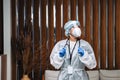 Oung woman nurse worker in medical protective mask, gloves and protective wear standing in hospital hall