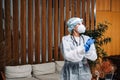 Oung woman nurse worker in medical protective mask, gloves and protective wear standing in hospital hall