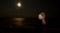 ÃÂ¡ouple kissing at the beach under moonlight