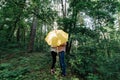 ÃÂ¡ouple in love under yellow umbrella in a forest