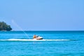 ÃÂ¡ouple, man and woman enjoy riding ski jet in blue ocean. Island on backgraund