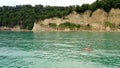 ÃÂ¡ouple surfers on supboard floating along shore on azure sea. Aerial view