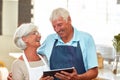 Our cafe deserves a social media page. a happy senior couple using a digital tablet to manage their small business. Royalty Free Stock Photo